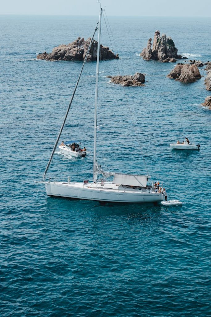 pexels-photo-13392672 Aerial view of sailing boats and rock formations in turquoise waters of Blanes, Spain.